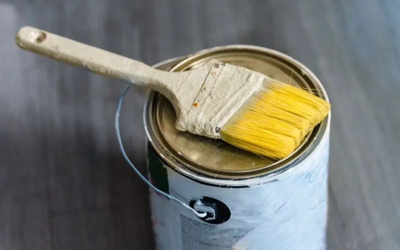 A close-up image of a paintbrush resting on a paint can, ideal for DIY projects.