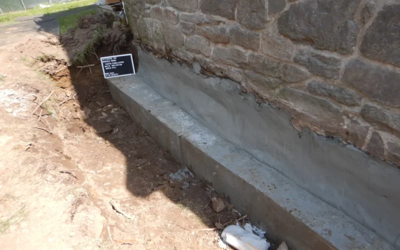 The foundation footer has been infilled and stabilized with concrete. There is a hole around the house foundation where construction workers dug to access the foundation pieces. The completed footer and foundation wall infills on the west elevation just prior to installation of waterproofing materials. Keywords: gettysburg; civil war; gettysburg national military park; battlefield; homes