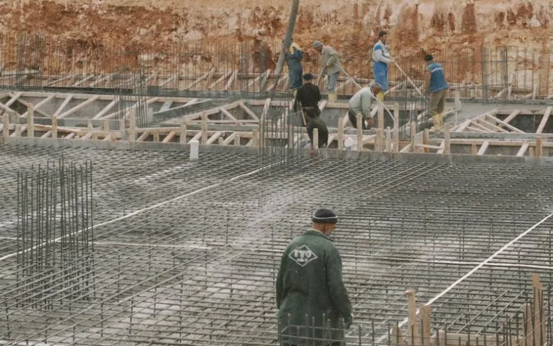 Workers building a foundation with rebar at a construction site.