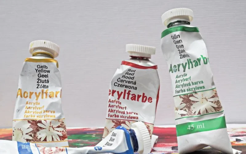 Close-up of colorful acrylic paint tubes on a canvas, ideal for arts and crafts projects.