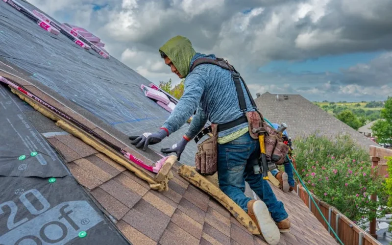 Roofers working on shingle installation on a home in Fort Worth, Texas under blue skies.