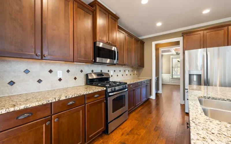 Elegant modern kitchen featuring wooden cabinets, stainless steel appliances, and granite countertops.