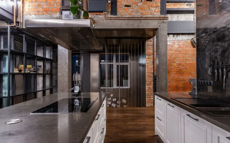 Interior of spacious kitchen area with modern furniture placed in luxury apartment in loft style