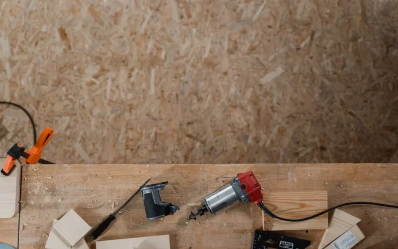 Aerial shot of carpentry tools on a wooden workbench, ready for woodwork.