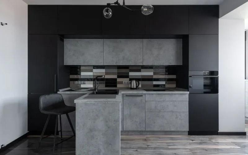 Sleek modern kitchen with black and gray cabinetry, perfect for minimalist decor.
