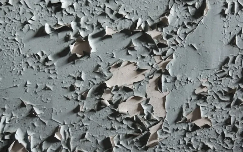 Detailed texture of cracked and peeling paint on an aged wall surface.