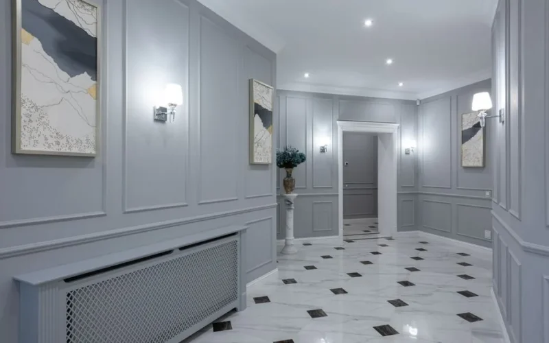 Interior of corridor of contemporary villa with shiny tiled floor and gray walls decorated with paintings and lamps