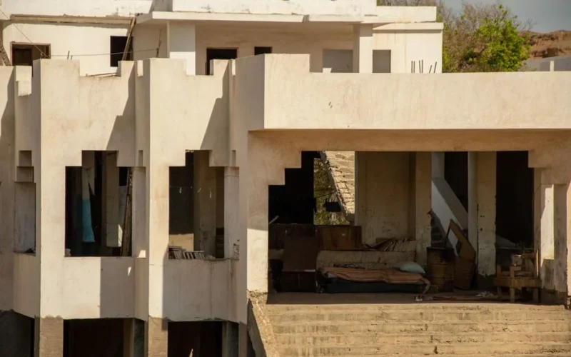 A partially abandoned residential building with incomplete construction details.