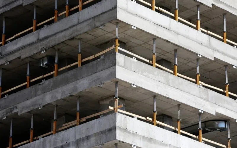 Close-up of an unfinished multi-level concrete building with steel reinforcements.