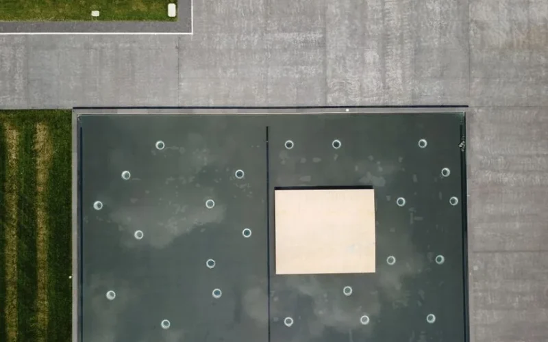 Drone view of a geometric rooftop and urban landscape in Kansas City, MO under daylight.