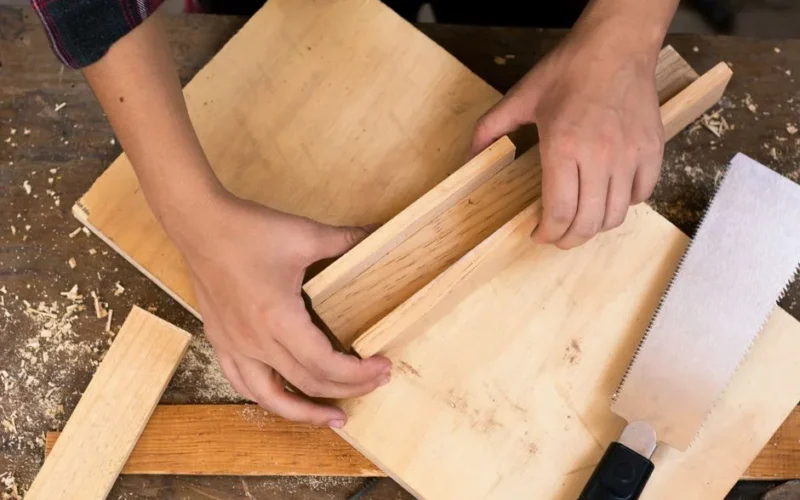 Close-up of hands crafting wood with tools, perfect for DIY carpentry and craft projects.