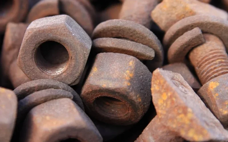 Close-up of a pile of rusty bolts and nuts showing detailed corrosion and texture.